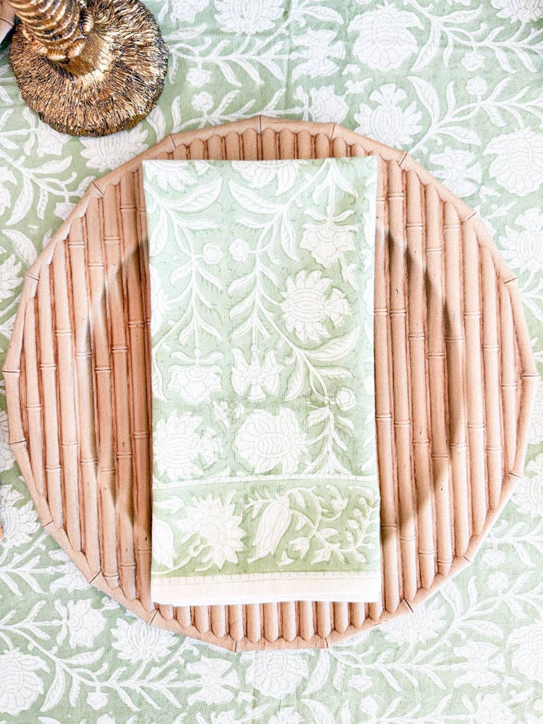 Woven placemat with floral pattern on a matching woven plate on a green floral background