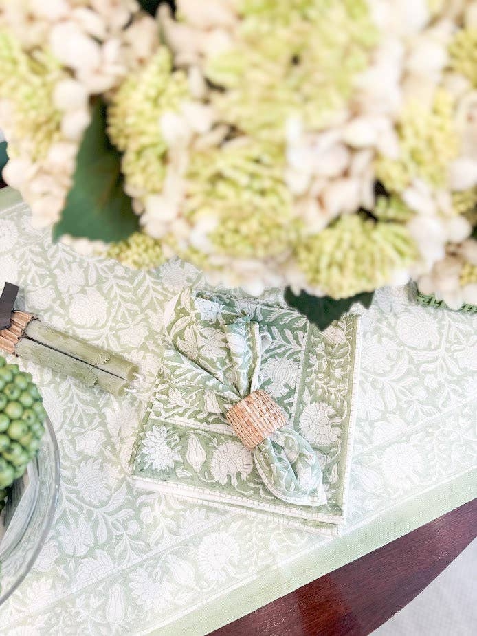 Decorative napkin with floral pattern on a table with green and white flowers.